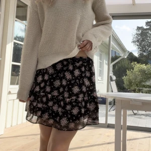 Blommig svart kjol - Svart kjol med blommor på. Står storlek 170, skulle säga att den är ungefär som xs. Resårband i midjan.