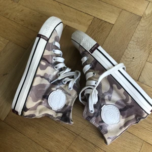 Tygskor  - Lite skimrande tygskor i brunt militär-mönster från Convince. Köpta på sellpy men oanvända, så gott som nyskick. 