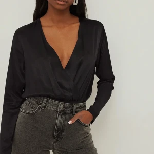 Oanvänd ECO satinbody  - Jättefin satinbody som passar fint till både byxor och kjol.  ECO märkt plagg 