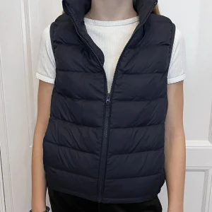 Väst från Uniqlo - Lätt och stilren mörkblå väst i jättefint skick. (Jag är 150 cm lång)