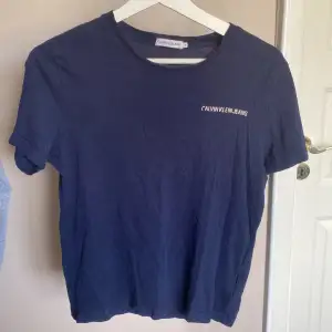 En mörkblå Calvin Klein t-shirt i storlek 152 men sitter som en XS på mig. Ganska använd och är i hyfsat skick, det ända som är lite slitet är trycket på vänster sida.💕