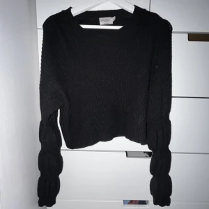 Stickad tröja  - Svart stickad tröja med puff längst ner på armen. I bra skick!!