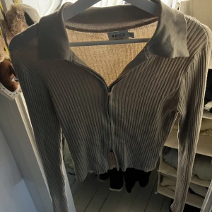 Tröja - En beige topp från NA-KD, med en justerbar dragkedja. I bra skick!!