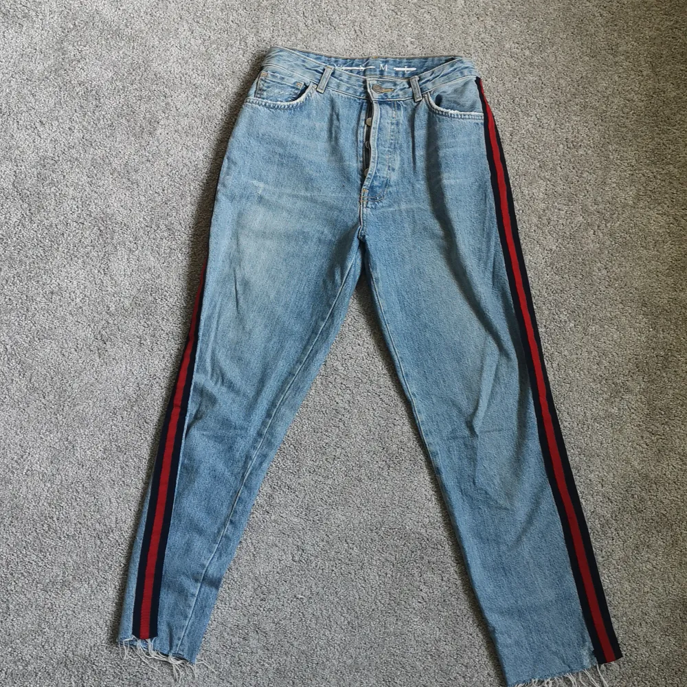 Ett par supercoola jeans med rödblåa streck vid sidorna. I momjeans-modellen och supersköna. I storlek M från never denim (Bikbok) . Jeans & Byxor.