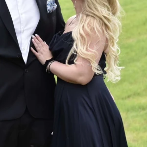 Balklänning  - färgen är mörk marin blå och materialet är likt satin. Klänningen har en slits vid höger ben och är öppen i ryggen med knytning. Klänningen är köppt för 2700kr i en brud butik för 2 år sedan. Säljer för 600kr. Använd en gång och är nästan som ny i skicket