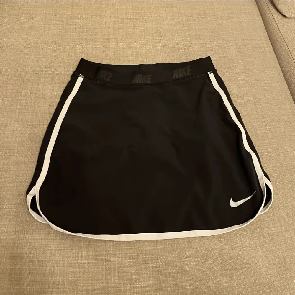 Nike Kjol ”tennis skirt” i svart. Det finns en ficka i den där man kan lägga saker. Under kjolen är det shorts under. . Kjolar.