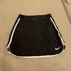 Kjol - Nike Kjol ”tennis skirt” i svart. Det finns en ficka i den där man kan lägga saker. Under kjolen är det shorts under. 