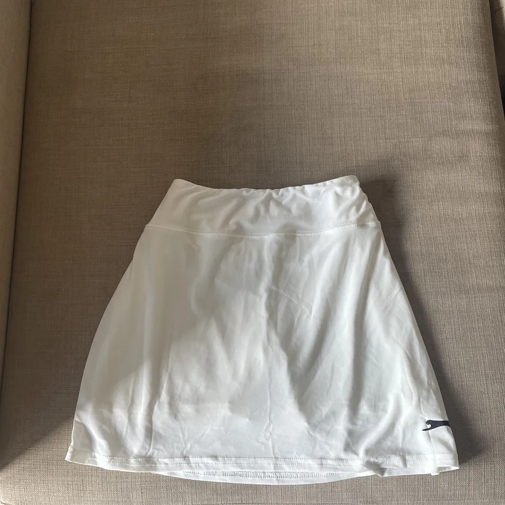 En super söt ”tenniskjol” i vit! Super söt och helt oanvänd. Passar S/M. Stretchigt material + dubbeltyg med shorts under ❤️. Kjolar.