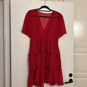Röd klänning med volanger från Nakd. Storlek L