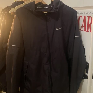 Nike vindjacka - Helt felfri. Väldigt praktisk jacka vid regn/ blåsigt väder.