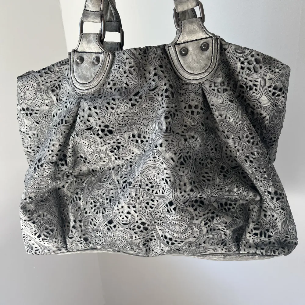 Galet cool väska i grå skiftande färg och unikt mönster. Längre band medföljer. . Väskor.