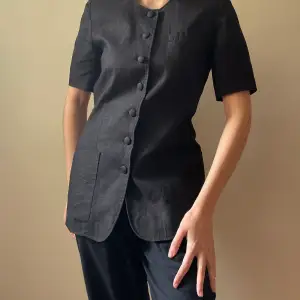 Vintage Cacharel Black Linen Boxy Blouse. 90s Top with 3 Frontal Pockets, Lightly Padded Shoulders & French Linen Covered Buttons.Feminine Round Neckline. Best Worn as a Fitted Look to keep cool in the Summer. Excellent Condition. Original Tag Size 36/6. 