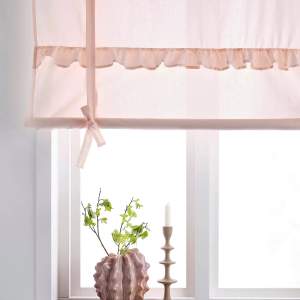 Roll up-gardin i ekologisk bomull. En aprikos-rosa färgad gardin med dekorativa volangdetaljer. Hängs på vanlig gardinstång. Höjden regleras med knytband. Den är tillverkad av 100% ekologisk bomull och är GOTS-certifierad.  Storlek: Maxhöjd 90cm och 120cm