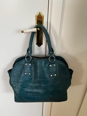 Vintage väska - Super härlig blå vintage väska i läder/ skinn. Den är väl använd men i bra skick, det är handtagen som börjat fransa sig lite, men lätt att bara klippa bort trådarna ( visas på bild 3)