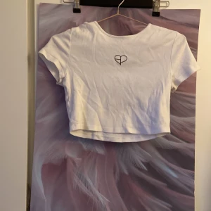 Tröja - En vit tröja från hm/divaded med ett litet svart hjärta, det är en magtröja. Använd kanske 5-6 gg och i bra skick! 10+frakt 