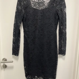 Klänning  - En mini svart klänning med öppen rygg