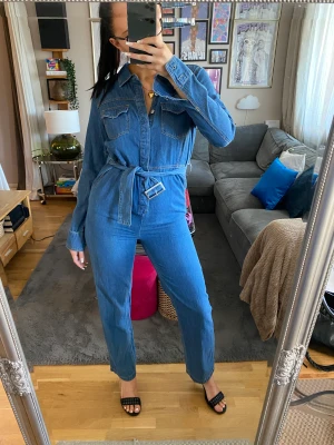 Dilara X nakd jeans jumpsuit🌐🌐🌐 - Jeans jumpsuit från Dilaras kollektion med NAKD. Jag är 173 cm och är strl s/m. Jag har knutit skärpet för de finns inget hål som sitter tillräckligt tight men man kan nog absolut göra egna hål för att få den tightare 🖤