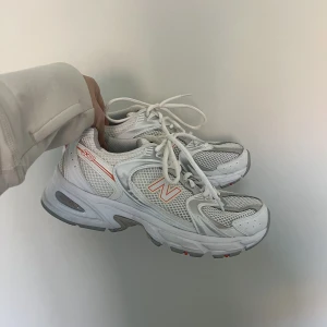New Balance 530 oanvända - Helt oanvända New Balance 530, vita med orange logga. Storlek 39,5 (längd: 24,5 cm)