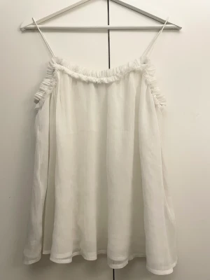 Linne Gina Tricot - Gulligt vitt linne i tunt materiel från Gina Tricot. Endast använt ett fåtal gånger. Mycket fint skick. 