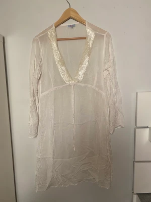 Supergullig klänning med glitter detaljer❤️ - En superfin klänning som har många olika användningar. Kan både vara en middagsklänning eller en strandklänning beroende på hur man stylar den. Super gulligt mönster med glitterdetaljer. Köpt ifrån lola i strl M.❤️