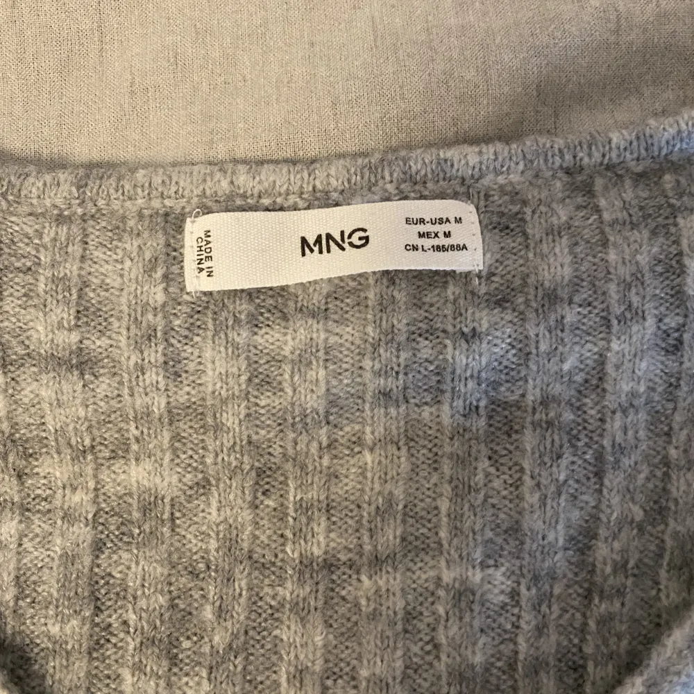 En grå stickad tröja från Mango i strl M. Väldigt sparsamt andvänd så i ett bra skick . Stickat.