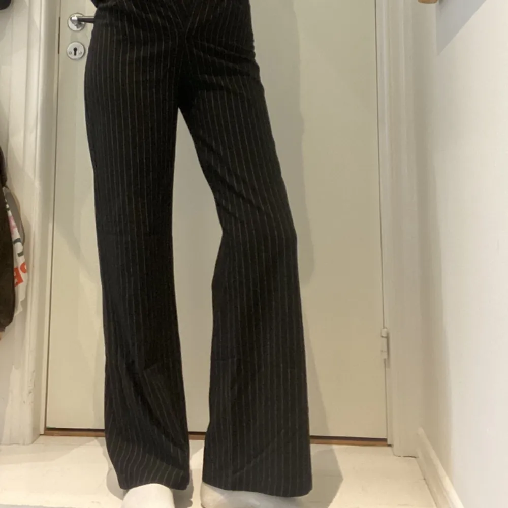 Ett par väldigt snygga svarta kostymbyxor med tunna vita ränder. De är raka/lite vida i modellen och väldigt bra längd på mig som är 1,73. Säljer då de blivit för små för mig🌸 Köpta från Bershka  . Jeans & Byxor.