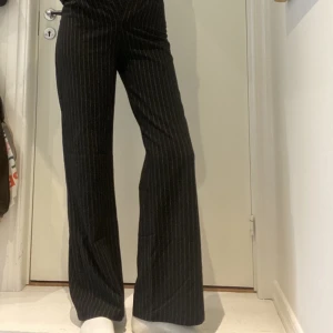 Snygga kostymbyxor!! - Ett par väldigt snygga svarta kostymbyxor med tunna vita ränder. De är raka/lite vida i modellen och väldigt bra längd på mig som är 1,73. Säljer då de blivit för små för mig🌸 Köpta från Bershka  