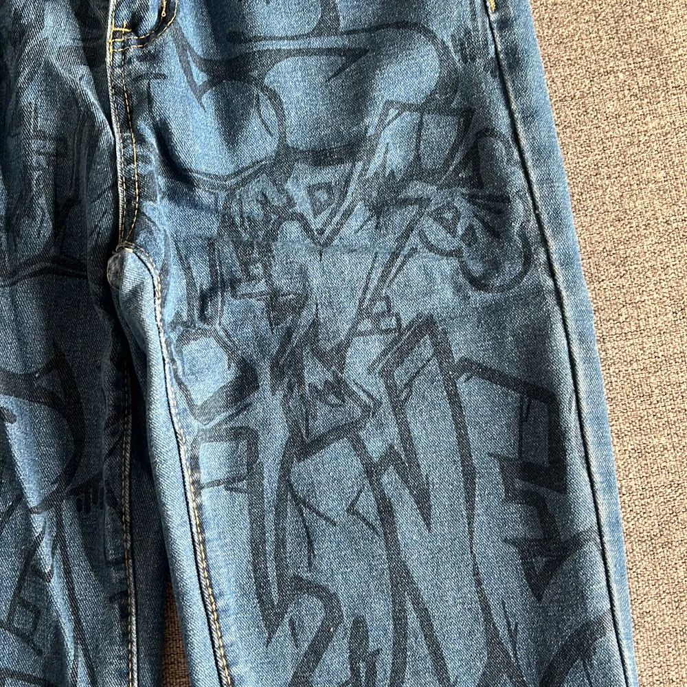 Jeans med graffiti mönster på övre delen av byxorna. Använt ett fåtal gånger så är i bra skick. Är storlek xs men passar som s. . Jeans & Byxor.