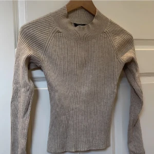 Beige tröja från LINDEX i nyskick!  - Beige ribbad topp från Lindex, 100% bomull och i jättebra kvalite och skick. Har använt den någon enstaka gång och tvättat den utan att den fått några noppror så verkligen superbra kvalite! Nypris 299 men slut i lager. Den är strechig så passar XS/S/M