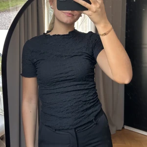 Svart T-shirt  - Svart T-shirt från Zara i storlek S. Helt ny och endast provad. Säljer då den inte kommer till användning. Har dock sett att den har ett hål uppe vid halsen (sista bilden) syns inte på långt håll💕
