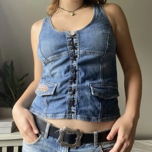 Jeans väst - Säljer min urcoola jeansväst från Harley Davidson. Inte bara har toppen snöringsdetaljer och fickor, men även platta nitar på ryggen. 