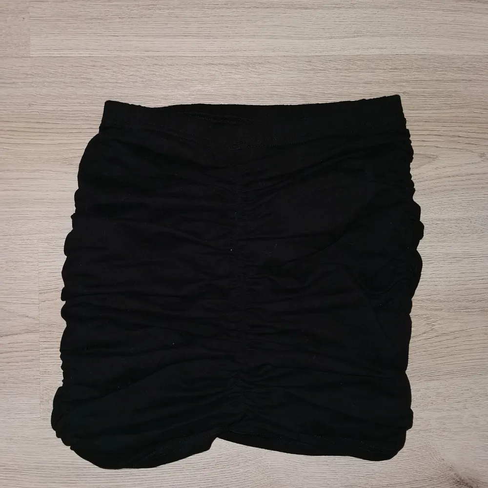Svart kjol med scrunch på båda sidorna och baksidan vilket framhäver baken;). Kjolar.