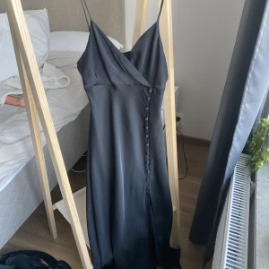 satinklänning med knappar - En svart sidenklänning med knappar längst sidan från Zara💗Så fin, endast använd några gånger så nyskick- men kommer inte till användning 