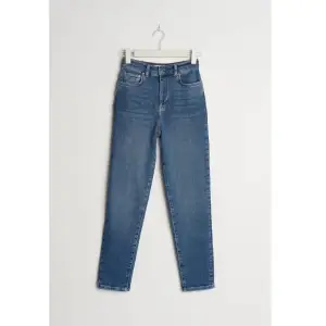 Mörkblå Mom jeans ifrån Gina tricot med stretch i storlek 40 (passar även mindre och större). Använda 1 gång. Köparen står för frakten. 