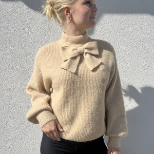 Stickad tröja - Beige stickad tröja med rosett! Nästan aldrig använd, så är i bra skick🫶🏻