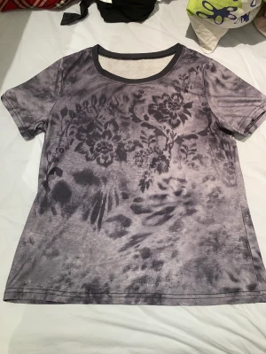 Blommig t-shirt  - Säljer den här coola t-shirten med blommtryck  Stolek står inte men skulle gissa s eller liten m