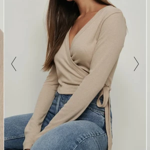Långärmad topp - Superskönt ribbat material. Toppen är omlott & knyts på sidan. Nyskick & oanvänd. Superfin att ha bakochfram också💕