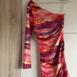 Enarmad klänning - Klänning med 1 arm, snören längst ner så det går att reglera längd