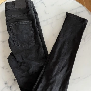 Svarta jeans med slits  - Svarta jeans från Nelly. Aldrig använda då dom var för stora. Slits längst ner. 
