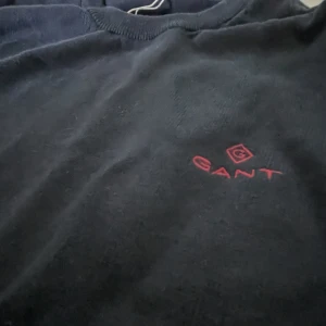 GANT tröja  - Gant tröja med röda detaljer. Färg: blå/svart  Nypris 1300kr Material: 100% bomull Väldigt bra skick. ——————————- Gant sweater with red details  Color: blue/black Bought for 1300kr Material: 100% cotton  In very good condition.  