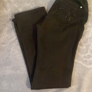 Svarta jeans - Tajta högst upp o sen blir de breda. Lågmejade är de o det sitter jättefint på kroppen