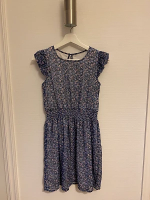 Klänning  - Mycket sommrig och fin klänning med blomm motiv. Klänningen är i storlek s och har dubbelt tyg.