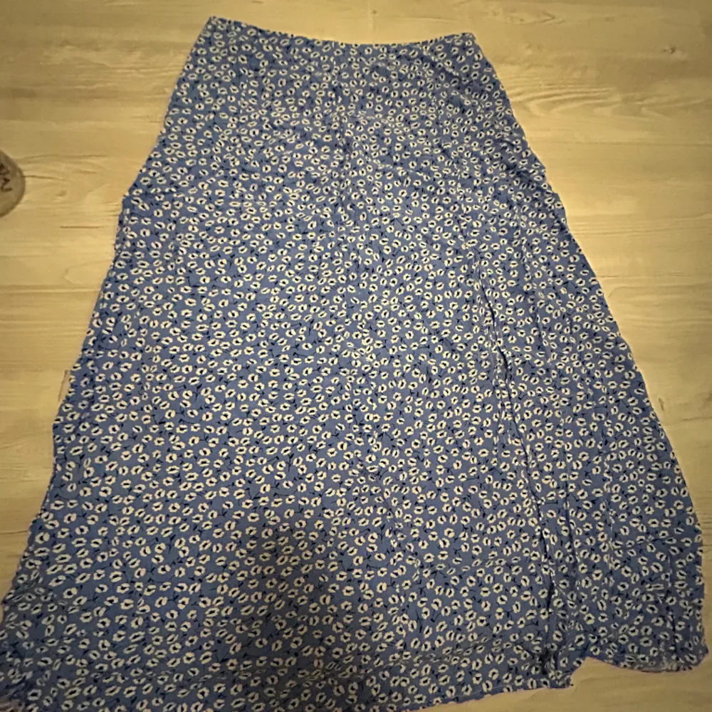Säljer denna super fina blå blommiga kjol från shein då den inte passar längre. Den har även ett litet slitt vid benet. Nypris runt 100kr nu 50kr. Kjolar.