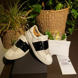 Valentino Garavani Rockstud Open Sneaker  - Hej! Säljer ett par populära Valentino Opens i vit färg med det ikoniska sträcket i glans. Storlek 41,5, passar även 42/42,5. Nypris 7280kr. Orginalbox, brev, fraktsedel & orderbekräftelse medkommer från köp. Fint skick med få tecken på användning. Hörs!