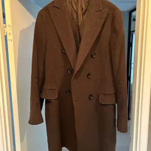 Säljer min Oscar Jacobson dubbelknäppta kappa i brun färg. Modell Sebastian och nypris ca 6499:- Storlek 50.   Välvårdad och använd vaksamt. 