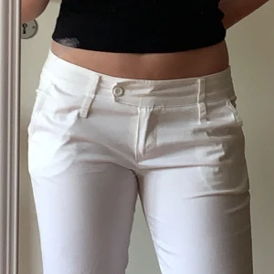 Lågmidjade kostymbyxor  - Jätte snygga vita lågmidjade kostymbyxor som är raka nertill. De går ända ner till golvet på mig som är 164 cm. 