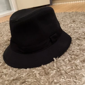Hatt - Svart hatt med en ögla på vänster sidan🖤