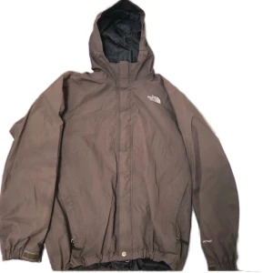 The North Face Hyvent jacka brun - En bra och skön Hyvent jacka från The North Face, brun. Bevis på äkthet i sista bilden. Ett lite hål i högra ärmen och normala tecken pa användning, dm för bild på det. Ska vara en 3 in 1 men fleecen saknas. Läs min bio. Dm för frågor och intresse