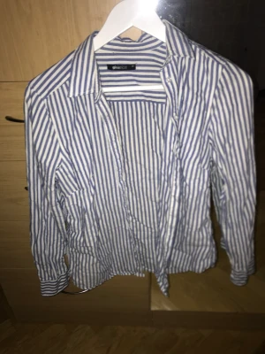 Skjorta från Gina Tricot  - Fin blårandig skjorta från Gina Tricot, köpte begagnat och har aldrig använt själv, väldigt fint skick. 