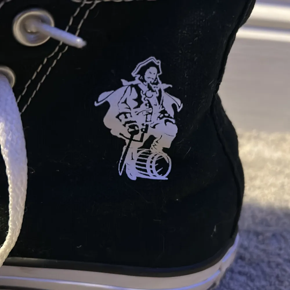 Svarta converse med vad jag tror är pirates of the Caribbean tryck på ena sidan. Jättefint skick. Storlek 36.5. Skor.